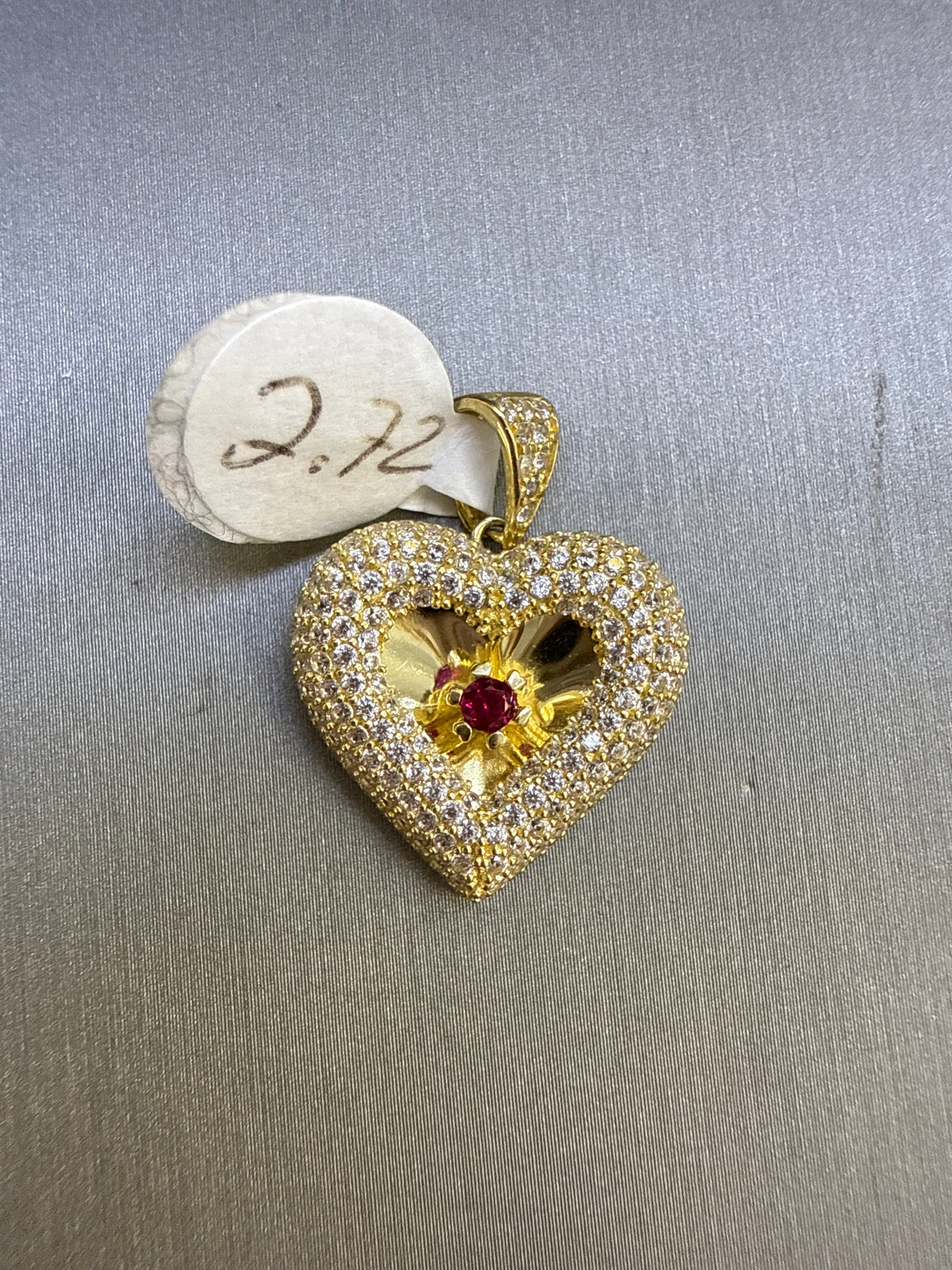 10k stone heart pendant with a single red stone in the middle